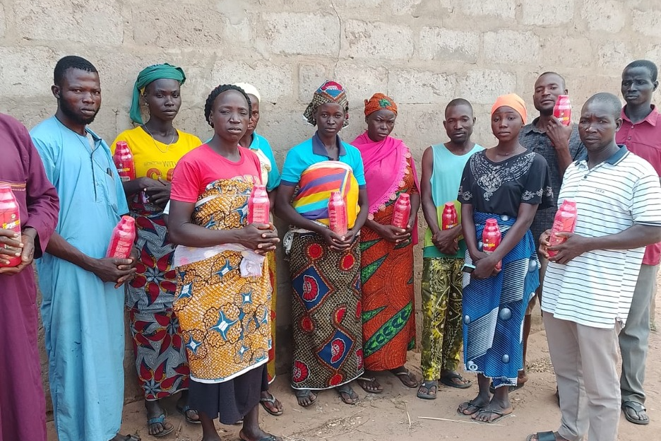 Farmers holding herbicide containers received at a safe-use training session, Agwara LGA, Niger State